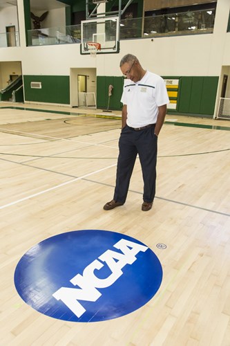 [Concordia University Irvine Athletics Director Mo Roberson is featured with the distinctive NCAA logo on the university's gym floor. ]